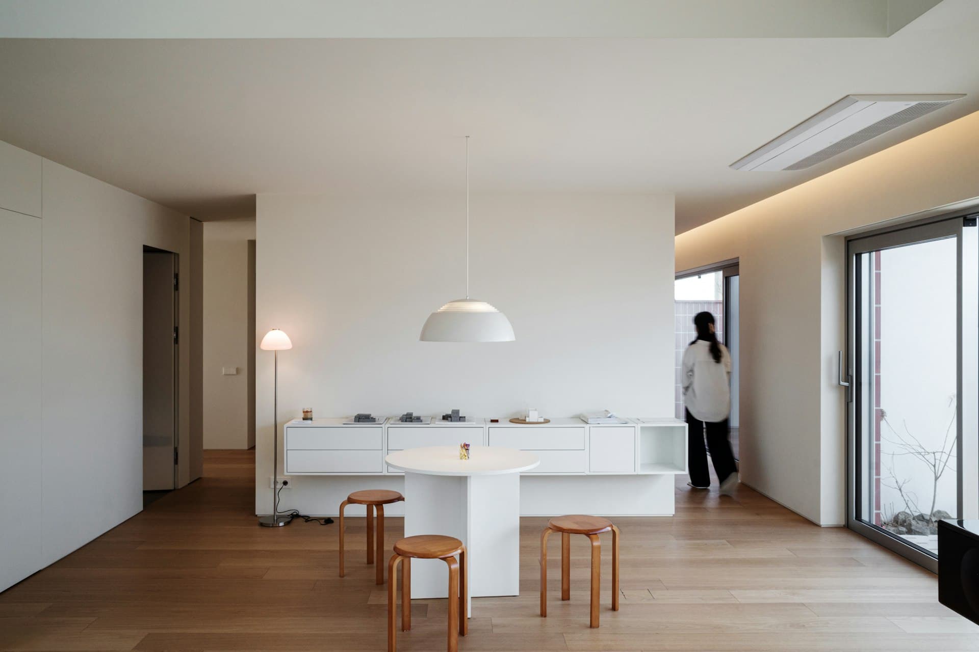 A minimalist Japanese apartment interior with wooden floors and warm light