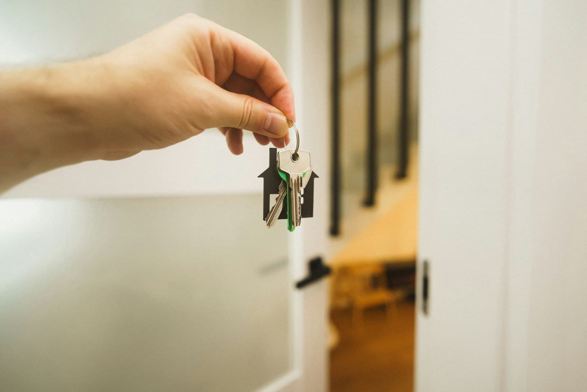 Hand holding a key to a new apartment door
